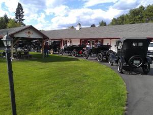 a group of old cars parked in front of a building at Maple Leaf Motel in Littleton