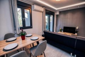 a dining room with a table and chairs and a television at Amphitrite Beach House in Agios Nikolaos