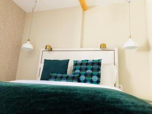 リスボンにあるCanarios Apartments Avenidaのベッドルーム1室(緑と青の枕が備わるベッド1台付)