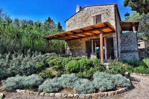 a stone house with a garden in front of it at Il Molino in Porto Ercole