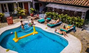 eine Gruppe von Personen, die um einen Pool herum liegen in der Unterkunft Viajero Hostel Cali & Salsa School in Cali