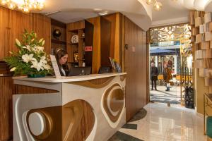 a woman sitting at a reception desk in a lobby at Be Poet Baixa Hotel in Lisbon