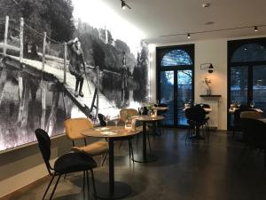 a restaurant with tables and chairs and a large painting on the wall at Hotel La Passerelle in Grandhan