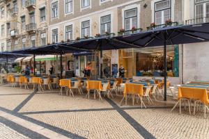 een groep tafels en stoelen voor een gebouw bij Be Poet Baixa Hotel in Lissabon