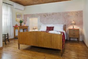 um quarto com uma cama grande e piso em madeira em Smaragda Stone Villa em Vamos
