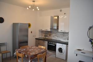 La cuisine est équipée d'une table, d'une cuisinière et d'un réfrigérateur. dans l'établissement Residence Borsellino 41, à Garbagnate Milanese