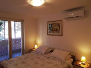 a bedroom with a bed with two lamps and a window at Comfortable 3* Apartment Lapad Center in Dubrovnik