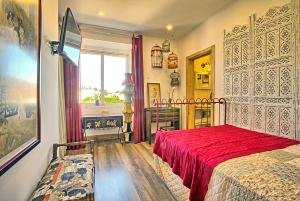 a bedroom with a red bed and a window at NINHO SALOIO in Venda do Pinheiro