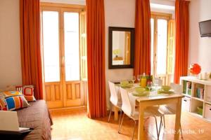 a living room with a dining room table with chairs at Apartamentos Madrid in Madrid