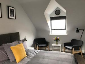 a bedroom with a bed and two chairs and a window at City Centre Townhouse-3 Bedrooms & Parking - Excellent Location in Belfast