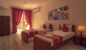 um quarto com duas camas e um quadro na parede em Bohemian Hotel - Negombo em Negombo