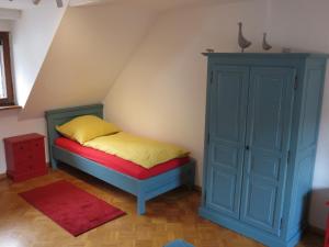 ein Schlafzimmer mit einem Bett und einem blauen Schrank in der Unterkunft Ferienwohnung am Gässle in Ettenheim