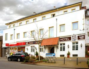 ein großes weißes Gebäude mit einem Hotel an einer Straße in der Unterkunft Hotel Bürgerhof in Köln