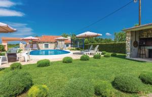 een tuin met een zwembad, stoelen en parasols bij Villa Neno in Donji Zemunik