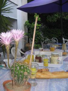 a table with a blue umbrella and flowers on it at Chambres d'Hôtes Béziers in Béziers