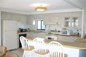 a kitchen with white cabinets and a table and chairs at Montego Bay - South Ocean Drive 203 in Ocean City