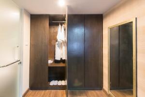 a closet with wood paneling and a glass door at The Cotai Luxury Design Hotel in Bang Bo