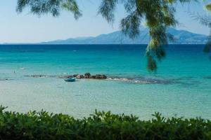 a beach with a boat in the middle of the water at mare di zante "mare di levante" in Alikanas