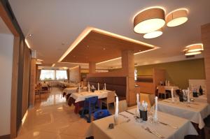 a dining room with white tables and chairs at Hotel Select in Andalo