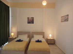two beds in a bedroom with two lamps on them at Katerina Apartments near the Sea in Zakynthos Town