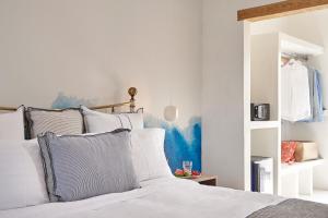 a bedroom with a bed with white sheets and pillows at Parian Boutique Hotel in Naousa