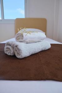 a pile of towels sitting on top of a bed at FIG TREE GIANNIS in Protaras