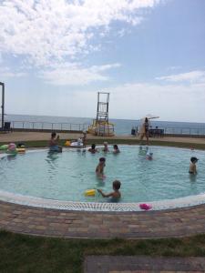 a group of people in a swimming pool near the ocean at Квартира у моря in Sochi