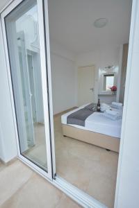 a bedroom with a bed and a sliding glass door at FIG TREE GIANNIS in Protaras