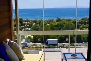 un soggiorno con divano e vista sull'oceano di Sea horizon penthouse flat ad Atene