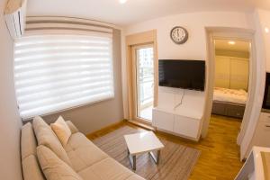 a living room with a couch and a tv at Central Budva apartment C15 in Budva