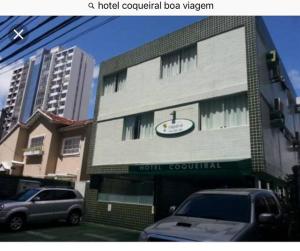 um vagão sequencial do hotel com carros estacionados à sua frente em Hotel Coqueiral no Recife