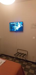 a room with a tv on a wall with a chair at Hotel Arcella in Padova