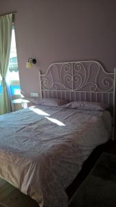 1 dormitorio con 1 cama con colcha blanca y ventana en Alborada De San Juan, en Beleño