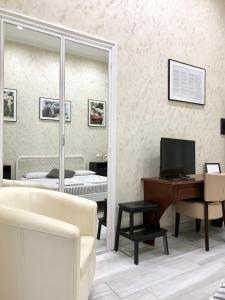 un soggiorno con TV, scrivania e letto di Bed No Breakfast AK a Napoli