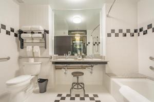 a bathroom with a toilet and a sink and a tub at Proximity Hotel in Greensboro