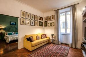 un soggiorno con divano giallo e letto di Colosseum Forum apartment a Roma