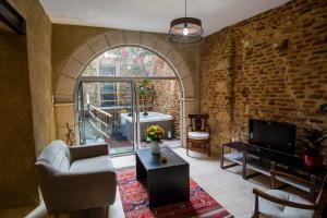a living room with an archway and a couch and a television at Appartement de charme au coeur de Bergerac in Bergerac