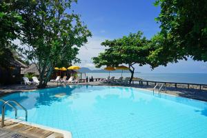 a swimming pool with a view of the ocean at The Sunset Village -SHA PLUS CERTIFIED in Na Jomtien