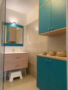La salle de bains est pourvue d'un lavabo et d'une armoire bleue. dans l'établissement Ô de Mer at My Luxury Home in Provence, à La Ciotat