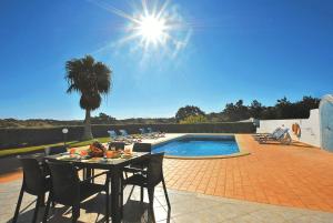 een tafel en stoelen naast een zwembad bij Villa Sardenha by Algarve Vacation in Guia