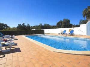 een zwembad met ligstoelen naast een huis bij Villa Sardenha by Algarve Vacation in Guia