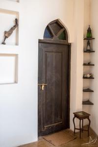 una vecchia porta in legno in una stanza con mensola di Casa Umoja a Nungwi
