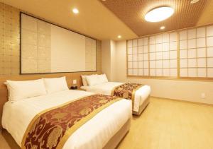 東京にあるArakawa-ku - Hotel / Vacation STAY 22245のベッド2台と大きなスクリーンのある部屋