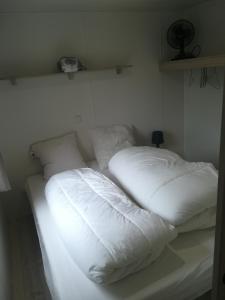- 2 oreillers blancs sur un lit dans l'établissement MOBIL HOME à QUIBERON 205, à Quiberon