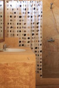 a bathroom with a sink and a shower curtain at Casa Umoja in Nungwi