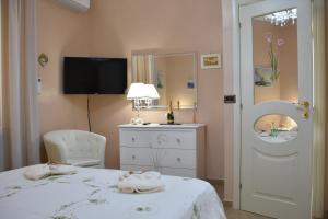 Schlafzimmer mit einem Bett, einer Kommode und einem Spiegel in der Unterkunft Il Corallo Rosso in Giardini-Naxos