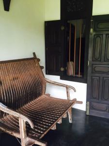 a wooden bench sitting in a room next to a door at Galle Henna Estate in Unawatuna