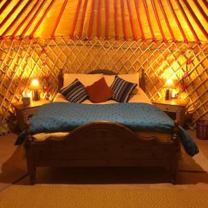 um quarto com uma cama numa tenda em McClure Yurt at Carrigeen Glamping em Kilkenny