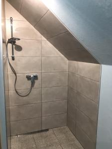 La salle de bains est pourvue d'une douche et de carrelage. dans l'établissement Apartament nad jeziorem Kątno Mazury, à Kątno