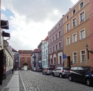 una calle de la ciudad con coches y edificios aparcados en Apartament Ducha NO'7, en Toruń